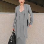 A beautiful professional model wearing an elegant grey pinstripe collarless blazer featuring a distinctive tie-front knot at the waist, styled with a crisp white collared shirt underneath for a modern corporate chic look.