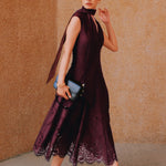 A chic woman wearing sunglasses and an elegant deep burgundy sleeveless V-neck A-line midi dress featuring textured jacquard fabric, delicate lace hemline, and a matching flowing neck scarf.