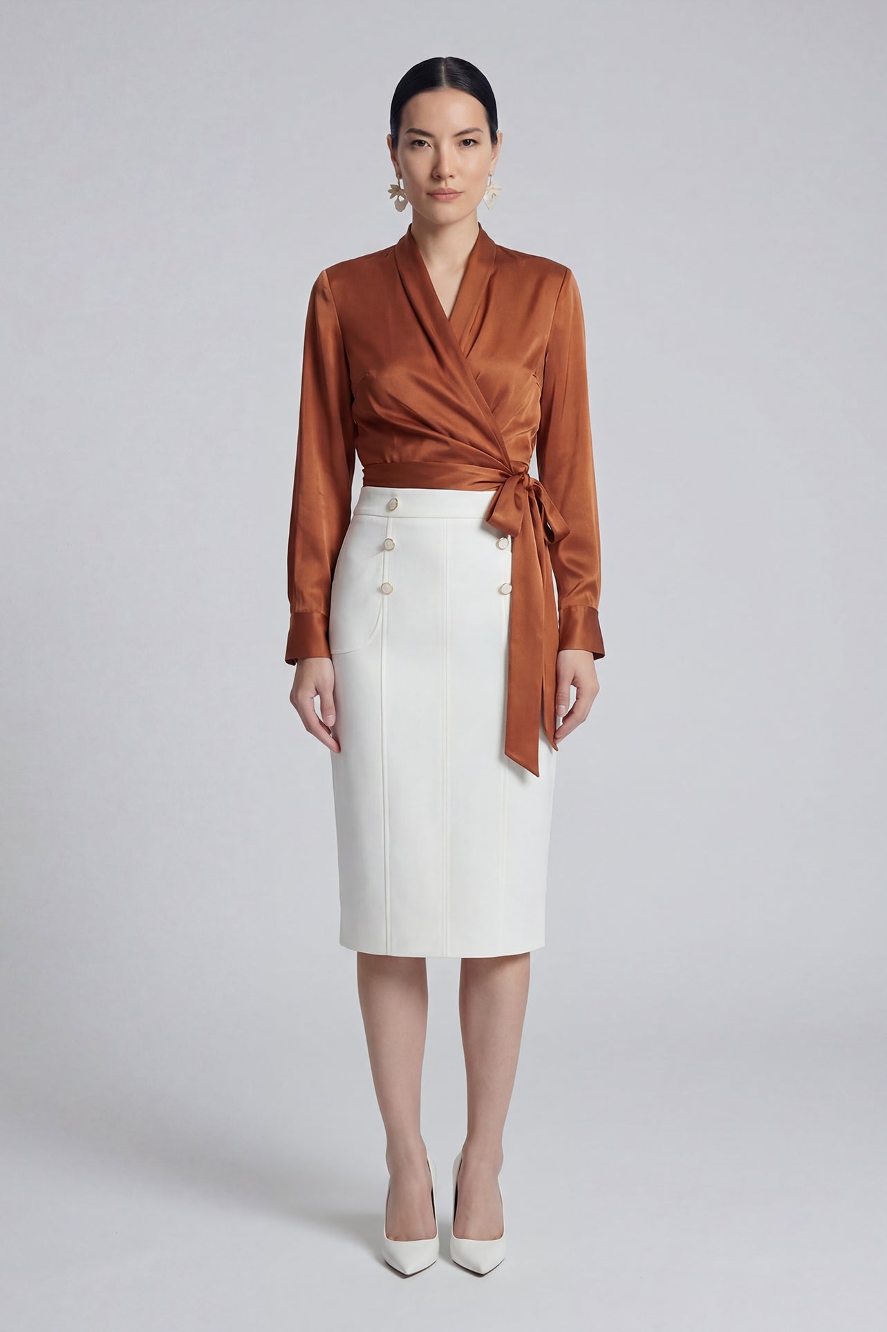 A professional woman wearing a sophisticated high-waisted white pencil skirt featuring elegant double-breasted button decorations and a slimming tailored fit, ideal for corporate business wear.