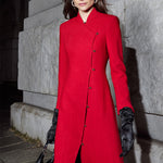 A professional woman smiling in a stunning festive red coat dress, featuring a stand-up mandarin collar with a large 3d rose ornament and an elegant side-button closure, perfect for a Christmas or holiday formal event.