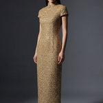 A professional woman wearing a stunning luxurious gold sequined modern qipao dress, featuring a traditional mandarin collar, short cap sleeves, and a slim-fit floor-length silhouette for a formal evening gala.