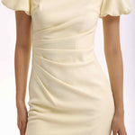 A professional woman wearing a sophisticated pale yellow short-sleeve midi dress, featuring elegant puff sleeves and a slimming ruched waistline for a polished and fresh summer office look.