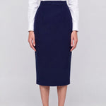 A professional woman wearing a classic navy blue high-waisted tailored pencil midi skirt with subtle front darts, neatly paired with a crisp white long-sleeve button-down shirt for an elegant corporate look.