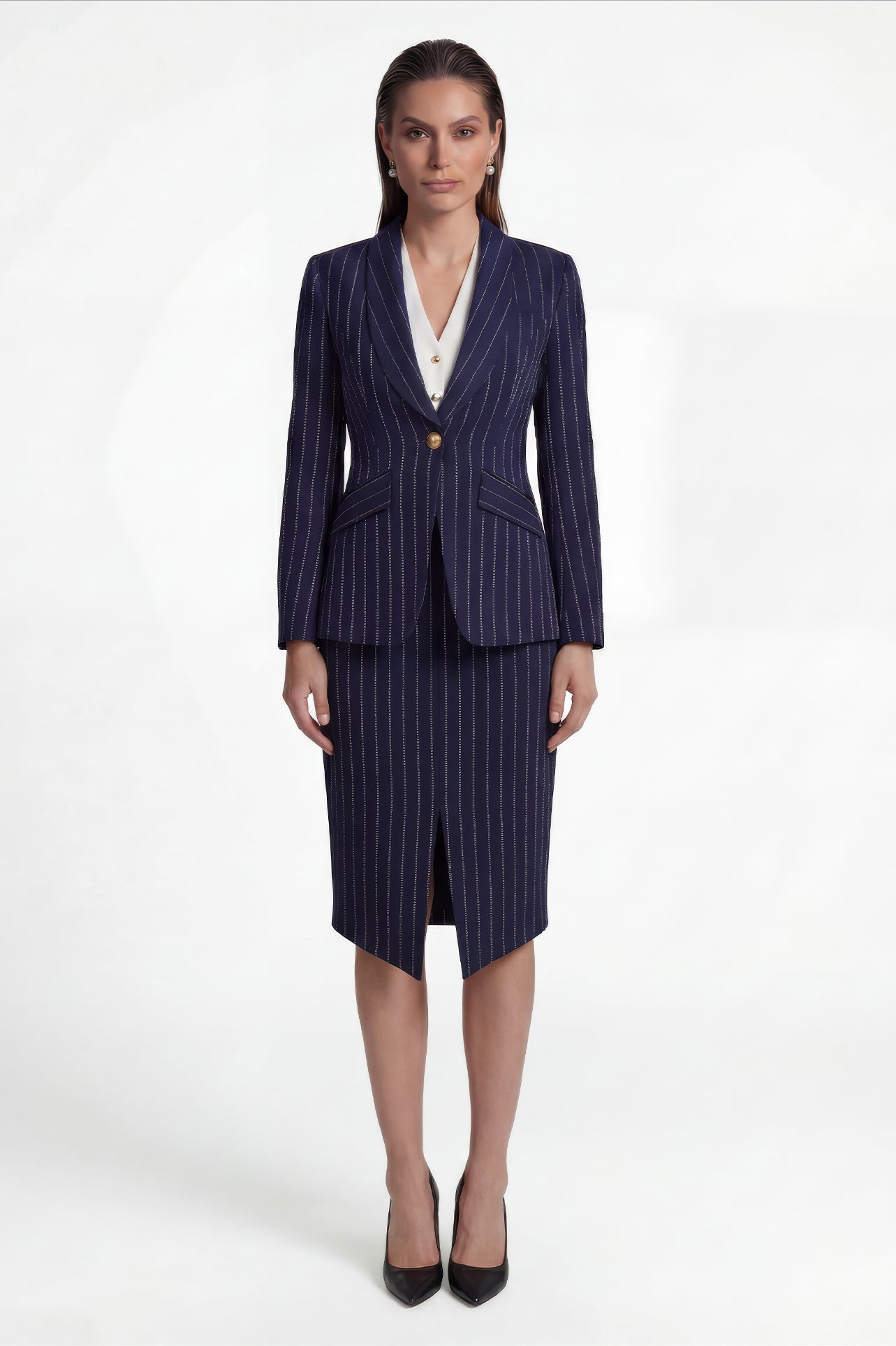 A professional woman wearing a sophisticated navy blue pinstripe suit, featuring a tailored single-button blazer and a matching midi pencil skirt with a front slit for an elegant executive office look.