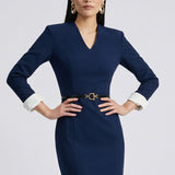 A professional woman wearing a sophisticated navy blue V-neck sheath dress, featuring elegant white contrast turn-up cuffs and a slim black belt with a gold buckle for a polished executive look.
