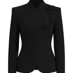 A professional woman wearing a sophisticated black skirt suit, featuring a mandarin collar with elegant leaf embroidery on the shoulder and skirt, and traditional frog button detailing for a modern oriental executive look.
