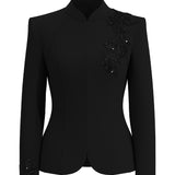 A professional woman wearing a sophisticated black skirt suit, featuring a mandarin collar with elegant leaf embroidery on the shoulder and skirt, and traditional frog button detailing for a modern oriental executive look.
