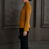 A chic professional Asian woman wearing a luxurious camel wool tailored jacket featuring a sleek stand collar, exposed two-way front zipper, structured shoulders, and an hourglass silhouette paired with a matching skirt.