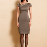 A professional woman wearing a sophisticated taupe grey sheath dress, featuring a chic asymmetric neckline, cap sleeves, and a tailored slim-fit silhouette for an elegant office look.