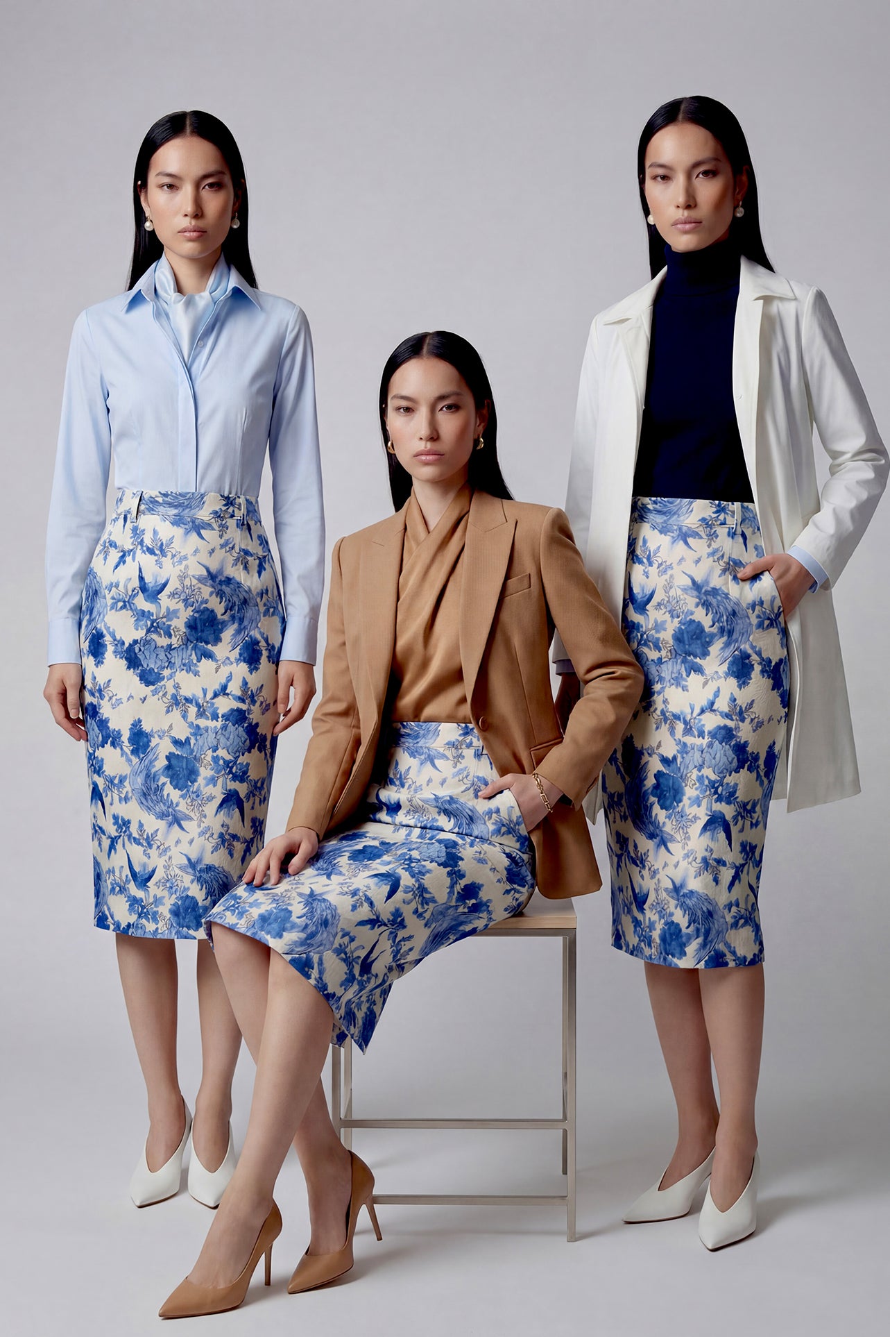 An elegant professional woman wearing a high-waisted pencil skirt featuring a sophisticated blue and white floral porcelain-style print, perfect for a polished office look.