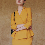 A style comparison of two elegant women's skirt suit sets featuring three-quarter sleeve blazers with single-button closure and pleated peplum hems, paired with matching pencil skirts in mustard yellow and deep teal blue.