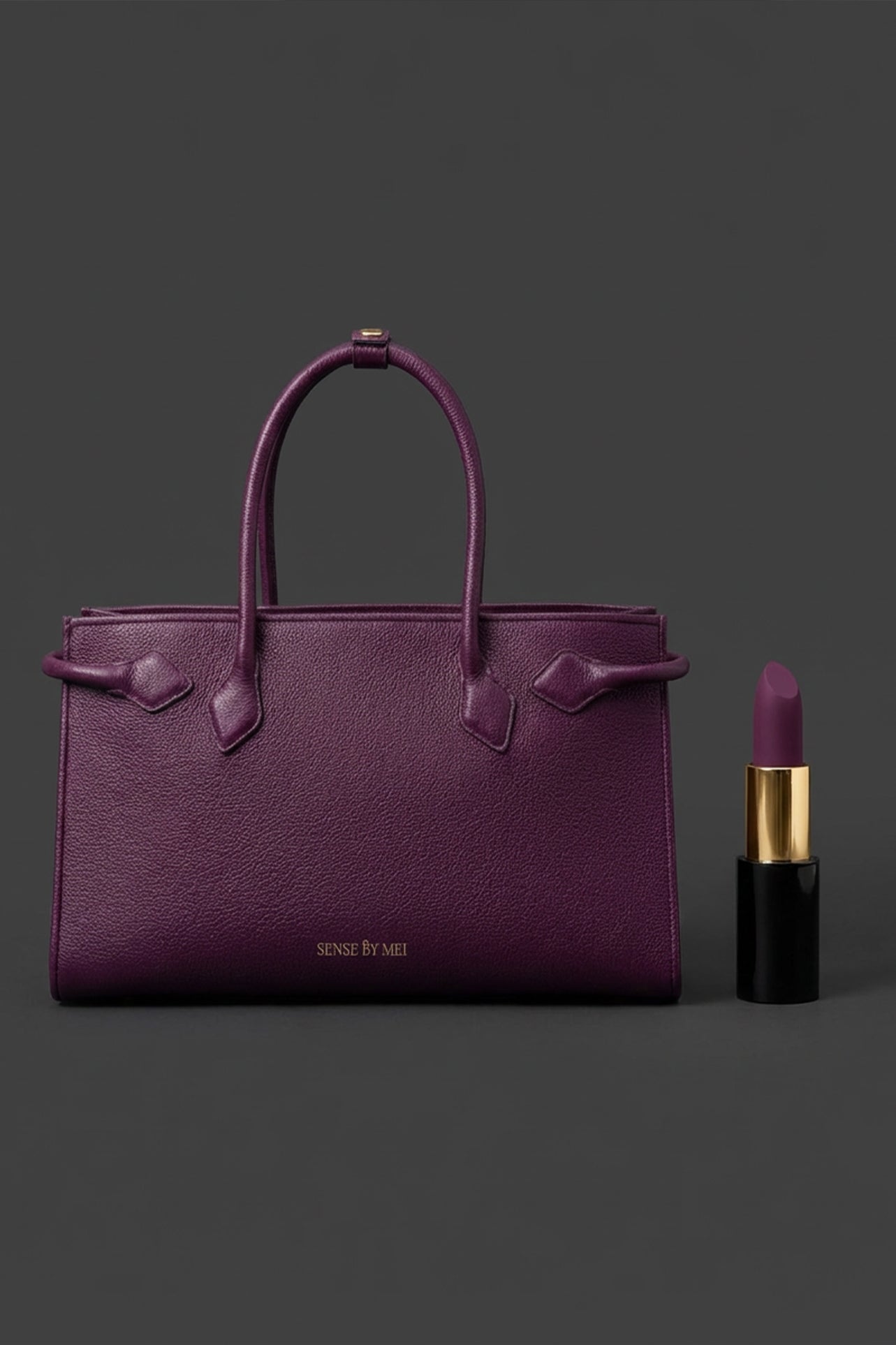 A sophisticated plum purple tote bag crafted from premium pebbled leather, displayed next to a matching shade of luxury lipstick, representing an elegant executive fashion set.