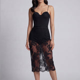An elegant woman wearing a sophisticated black floral lace midi skirt, featuring a sexy sheer lace overlay with a delicate scalloped hem and a tailored slim fit for a formal evening look.