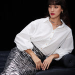 A woman wearing a glamorous high-waisted pencil skirt featuring shimmering silver and black sequins in a stylish zebra print, ideal for an elegant evening party or a night out.