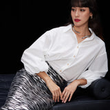 A woman wearing a glamorous high-waisted pencil skirt featuring shimmering silver and black sequins in a stylish zebra print, ideal for an elegant evening party or a night out.