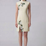 A professional woman wearing a stunning lemon yellow sleeveless mini dress, featuring a traditional mandarin collar, exquisite white floral 3D embroidery, and an elegant side slit for a sophisticated modern oriental look.