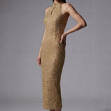 A stunning professional model wearing a luxurious gold sequined halter neck evening gown, featuring a sophisticated keyhole neckline and a slim-fit silhouette for a formal gala look.