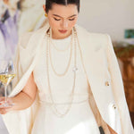 A professional woman wearing a sophisticated cream white double-breasted tweed blazer, featuring elegant gold buttons, a tailored slim fit, and classic flap pockets for a polished executive look.