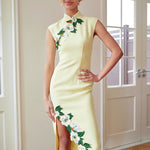 A professional woman wearing a stunning pale yellow sleeveless dress, featuring a traditional mandarin collar, exquisite white floral embroidery appliques along the neckline and hem, and an elegant side slit for a sophisticated modern oriental look.