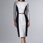 A professional woman wearing a sophisticated black and white color-block midi dress, featuring slimming side panels, long sleeves, and an elegant black belt with a gold buckle for a modern executive office look.