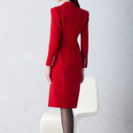 A sophisticated woman walking in London wearing an elegant vibrant red wrap coat dress, featuring a tie-waist belt and notched lapels for a polished executive street style look.