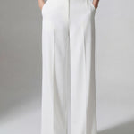 A professional woman wearing sophisticated black high-waisted wide-leg trousers, featuring a flattering high-rise fit and a flowing full-length silhouette for an elegant office look.