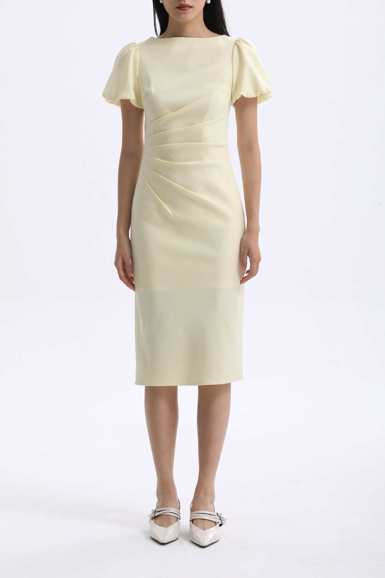 A professional woman wearing a sophisticated pale yellow short-sleeve midi dress, featuring elegant puff sleeves and a slimming ruched waistline for a polished and fresh summer office look.