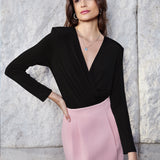 A professional woman wearing sophisticated high-waisted wide-leg pinstripe trousers in charcoal black, featuring a tailored slimming fit for a powerful executive office look.