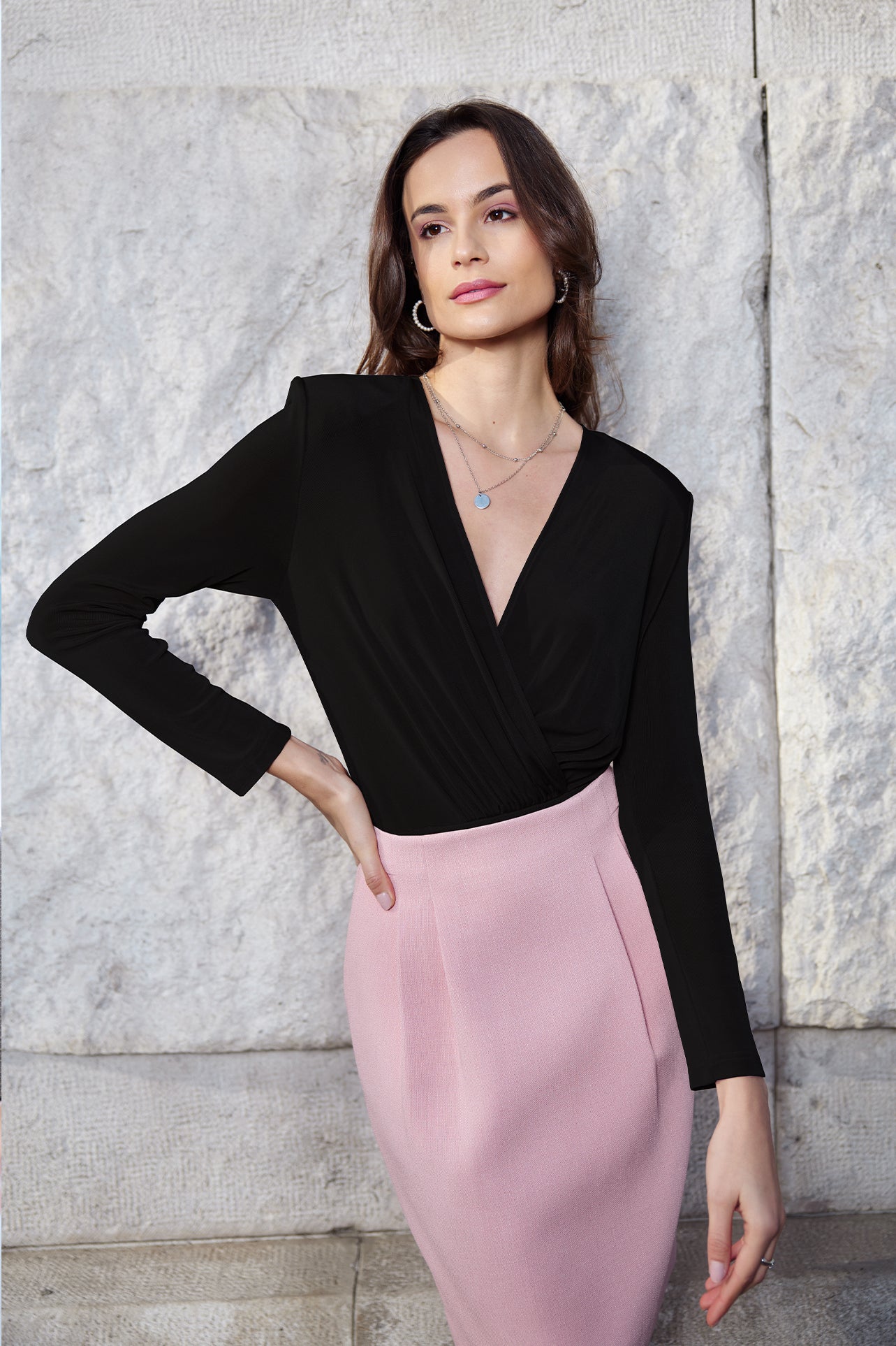 A professional woman wearing sophisticated high-waisted wide-leg pinstripe trousers in charcoal black, featuring a tailored slimming fit for a powerful executive office look.