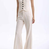 A professional woman wearing sophisticated cream pinstripe high-waisted wide-leg trousers, featuring a tailored loose-fit silhouette and styled with a pearl handbag for an elegant old money office look.