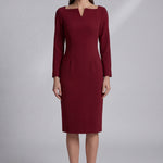 A professional woman wearing a sophisticated black long-sleeve midi dress, featuring a unique notched square neckline and a tailored slim-fit pencil silhouette for a polished executive office look.