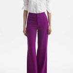 A professional woman wearing sophisticated black high-waisted straight-leg trousers, featuring a tailored silhouette with creased front details for a polished executive office look.