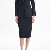 A professional woman wearing a sophisticated black belted blazer dress, featuring a tailored slim-fit silhouette with a waist-defining belt for a powerful executive business look.