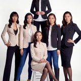 A professional woman wearing a sophisticated black skirt suit, featuring a mandarin collar with elegant leaf embroidery on the shoulder and skirt, and traditional frog button detailing for a modern oriental executive look.