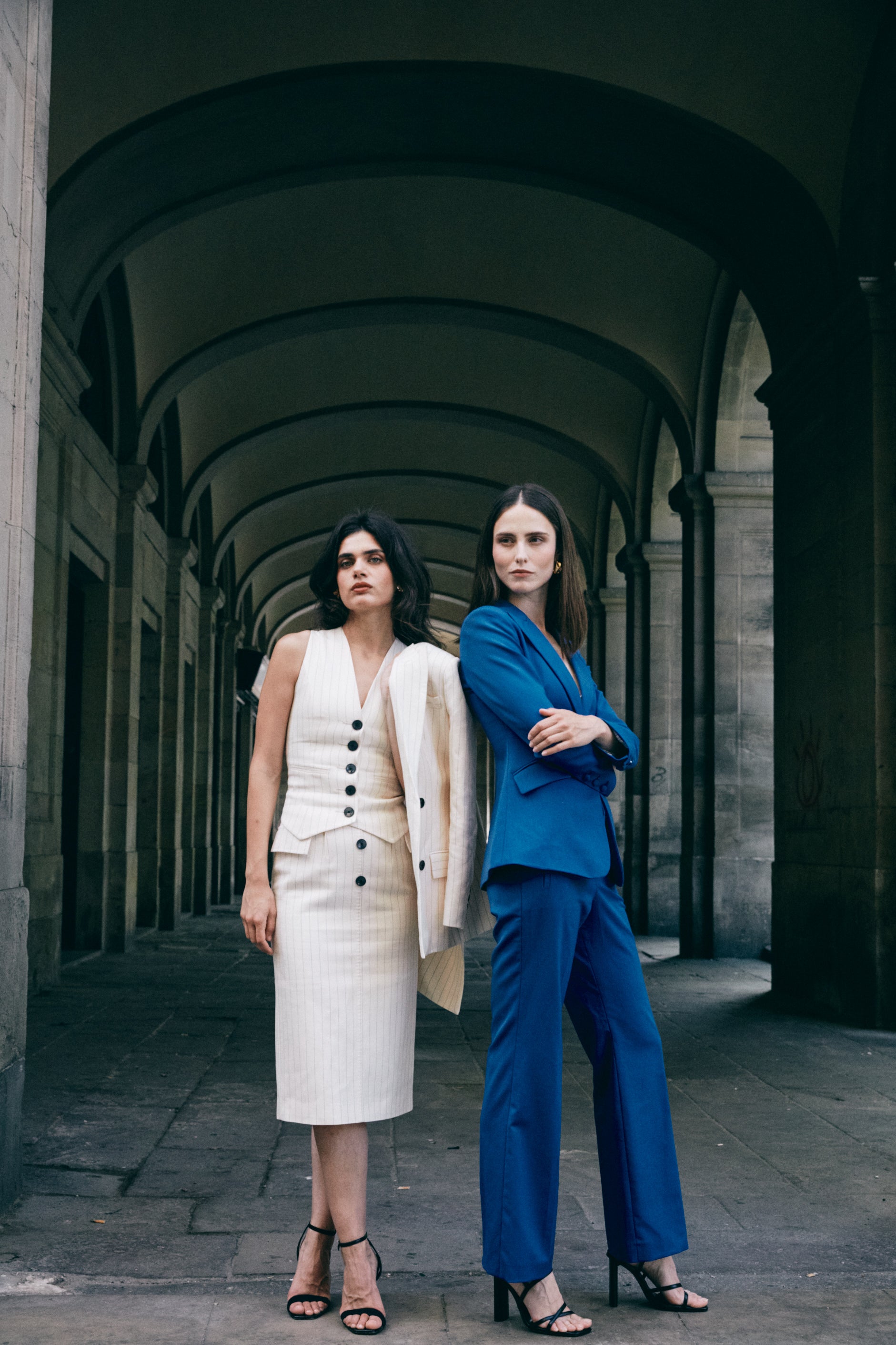 A professional woman wearing sophisticated royal blue high-waisted wide-leg trousers, featuring a tailored loose-fit silhouette for a modern and vibrant executive office look.