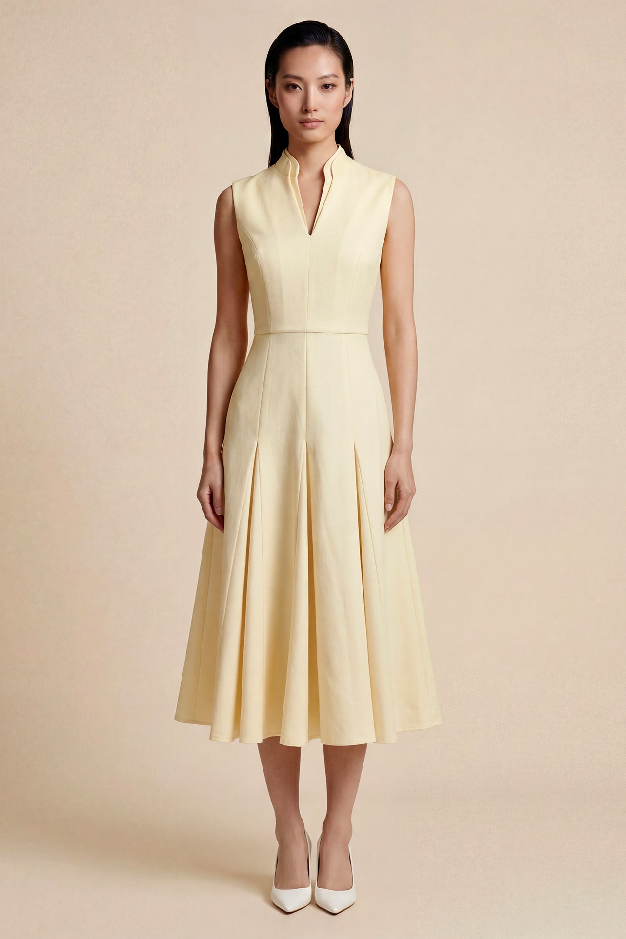 A side-by-side comparison of an elegant pale yellow sleeveless dress in two lengths, featuring a sophisticated mandarin collar, a stylish bow tie-waist, and a pleated A-line skirt for a classic feminine look.