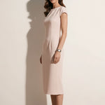 A professional woman modeling an elegant pale pink sheath dress, featuring a sophisticated crew neckline, cap sleeves, and a tailored slim fit with princess seams for a timeless executive look.