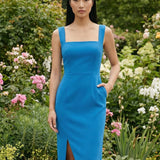 Two professional models wearing elegant square-neck sheath dresses in crisp white and vibrant mid-blue, featuring a tailored slim fit, a front slit, and a functional side pocket for a sophisticated office or social look.