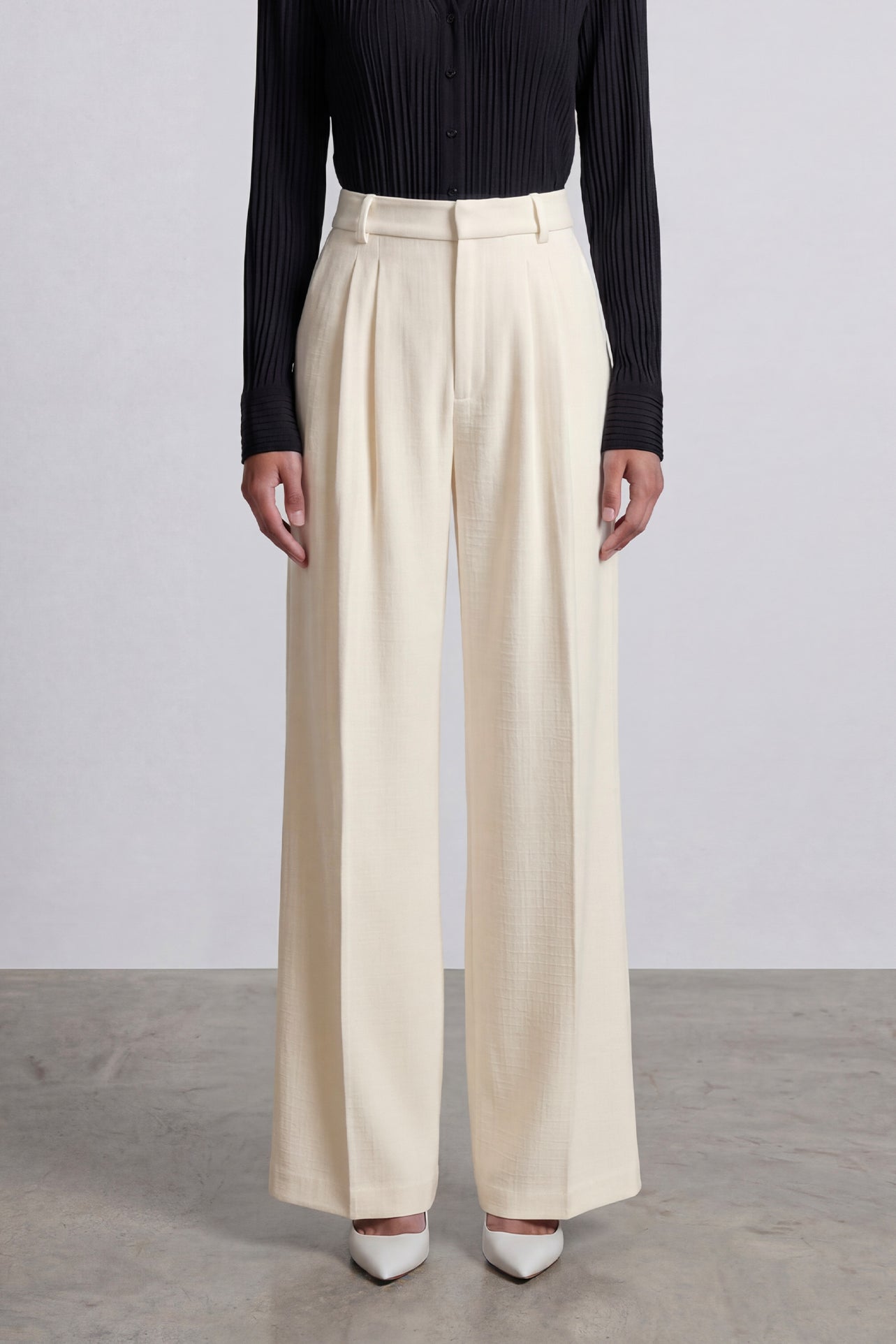 Comparison of elegant navy blue and ivory cream high-waisted wide-leg trousers, featuring sophisticated pleated front details and a tailored relaxed fit for professional office wear.