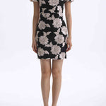 A professional woman wearing a modern black mini qipao dress, featuring elegant white floral embroidery, voluminous puff sleeves, and a chic keyhole neckline with a mandarin collar for a stylish party look.