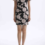 A professional woman wearing a modern black mini qipao dress, featuring elegant white floral embroidery, voluminous puff sleeves, and a chic keyhole neckline with a mandarin collar for a stylish party look.