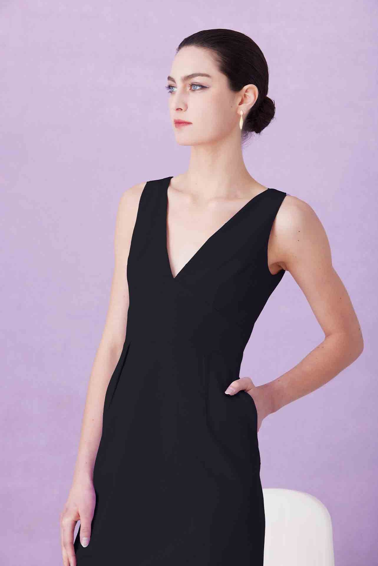 A professional woman showcasing two elegant sleeveless V-neck sheath dresses in classic black and soft lilac purple, featuring functional side pockets and a tailored fit for a polished office look.