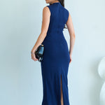 A professional woman wearing a sophisticated navy blue sleeveless midi dress, featuring an elegant high neckline and flattering ruched detailing along the side for a slim-fit executive look.