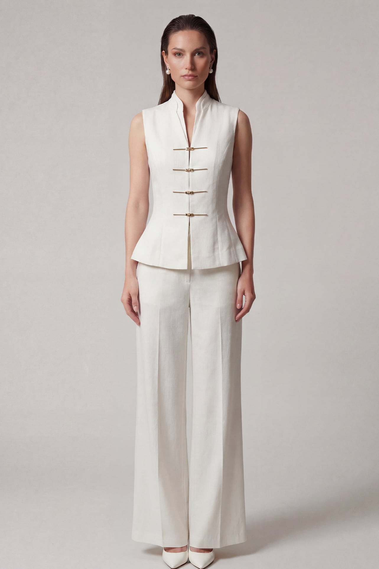 A professional woman modeling stylish high-waisted wide-leg trousers in a classic black pinstripe pattern, featuring sophisticated front pleats and a flattering long-line silhouette for an elegant office look.