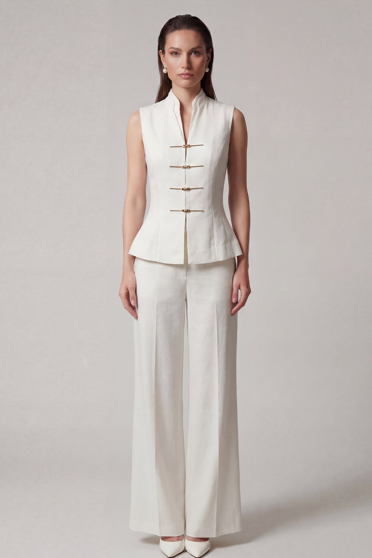 A professional woman modeling stylish high-waisted wide-leg trousers in a classic black pinstripe pattern, featuring sophisticated front pleats and a flattering long-line silhouette for an elegant office look.