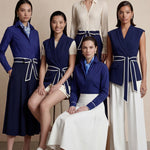 A group of elegant women wearing sophisticated modern qipao dresses in various colors like white, purple, yellow, and black, styled with luxurious fur shawls and embroidery for a high-end social gathering.