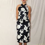 A professional woman wearing a stunning black sleeveless qipao-inspired dress, featuring a chic halter neck with a traditional mandarin collar and large elegant white floral embroidery for a modern oriental evening look.