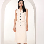 A professional woman wearing a sophisticated off-white pinstripe vest top, featuring a slim-fit tailored silhouette, classic V-neck, and contrasting black buttons for a modern business casual look.