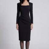 A professional woman wearing a sophisticated deep magenta long-sleeve pencil dress, featuring a unique square neckline and elegant ruched detailing at the waist for a flattering, slim-fit executive look.