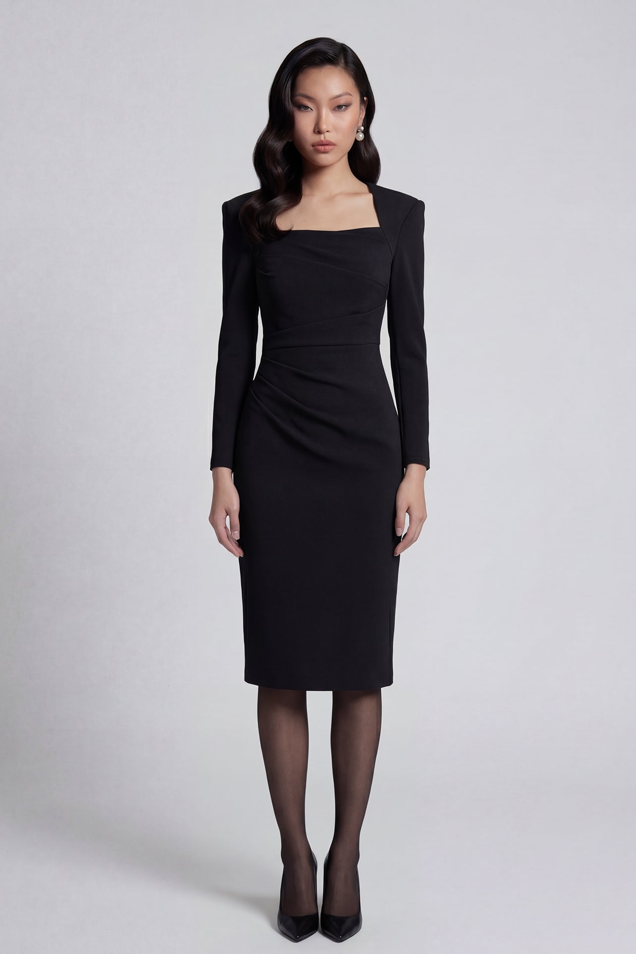 A professional woman wearing a sophisticated deep magenta long-sleeve pencil dress, featuring a unique square neckline and elegant ruched detailing at the waist for a flattering, slim-fit executive look.